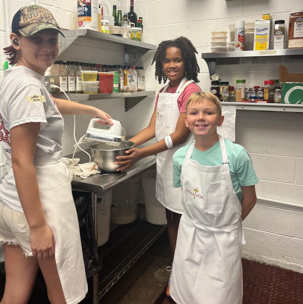 Nolavore campers use a mixer to mix ingredients