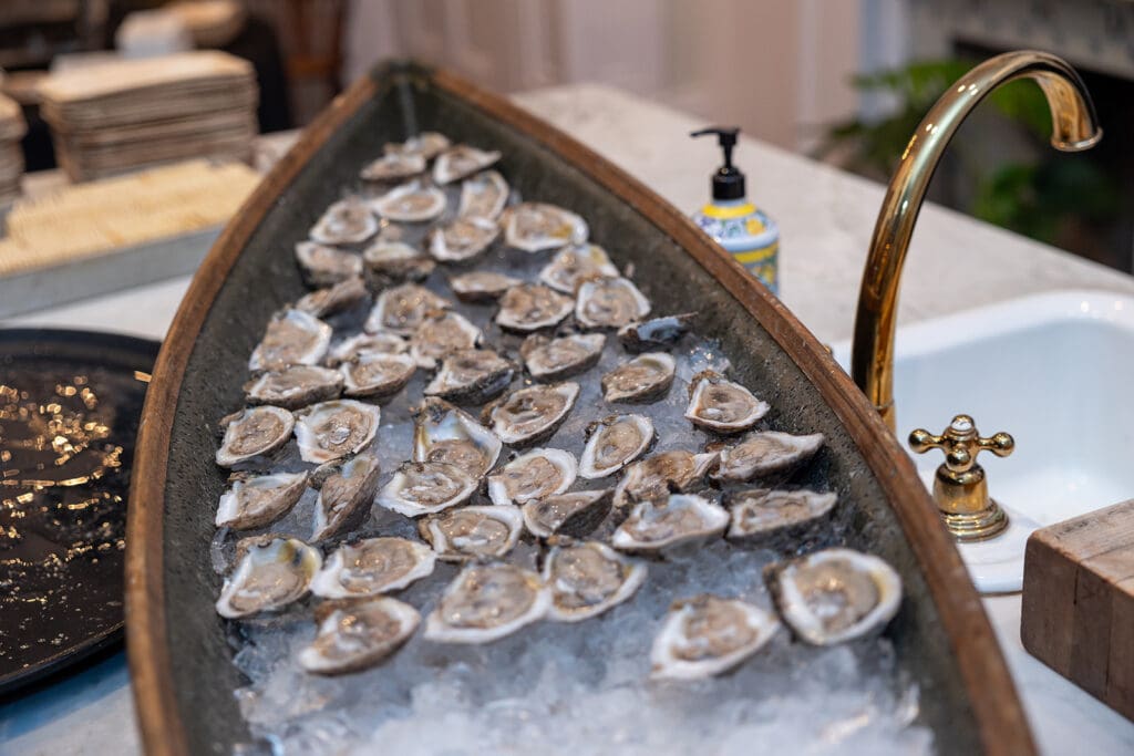 A long canoe-like tub of ice with raw oysters on the half-shell