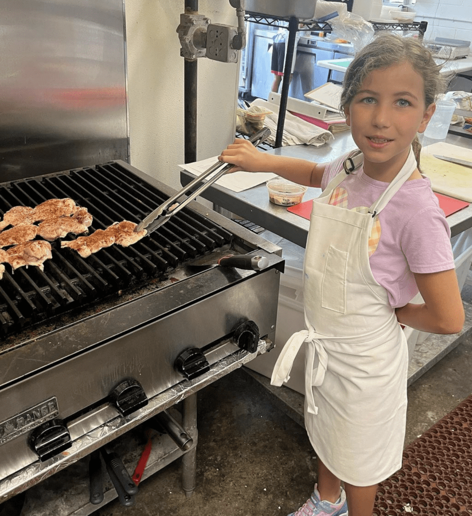 Nolavore camper cooks chicken on the stovetop