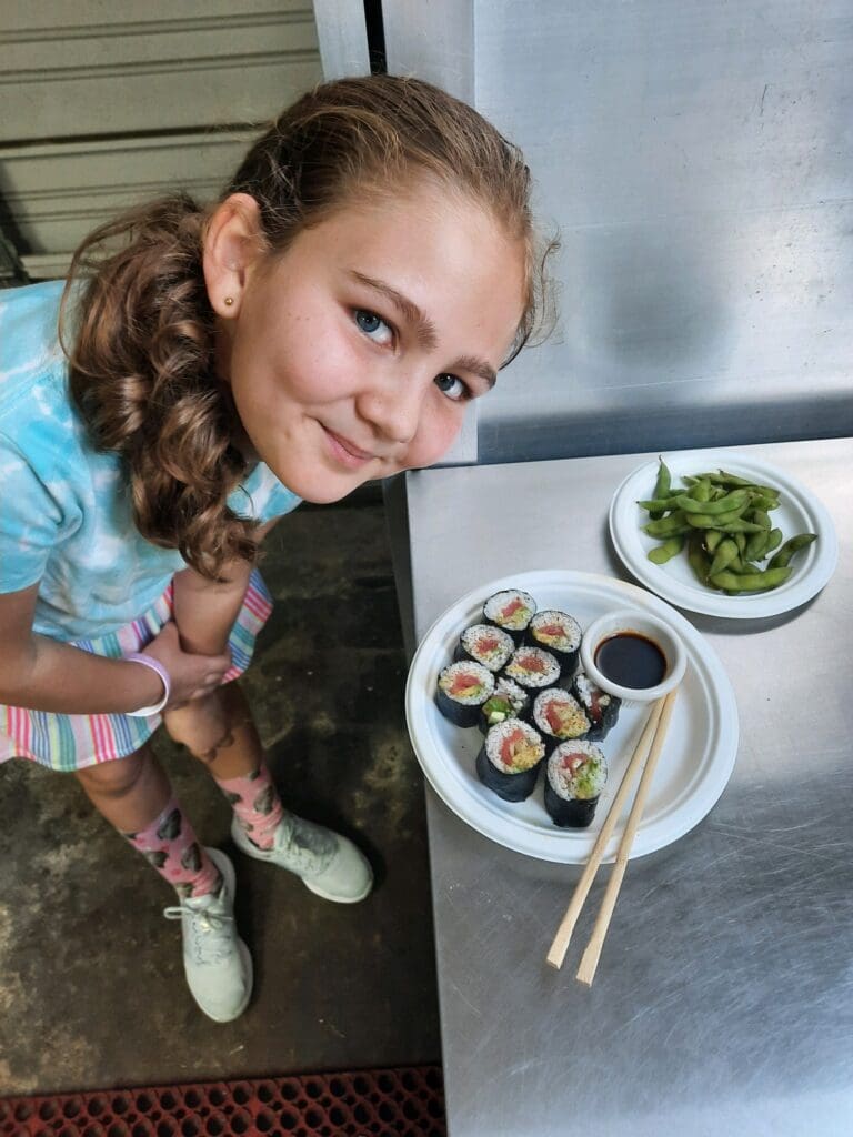 Nolavore camper poses with sushi and edamame she made