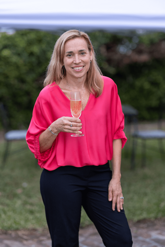 Anne Lloyd, owner of Nolavore, holds a flute of champagne