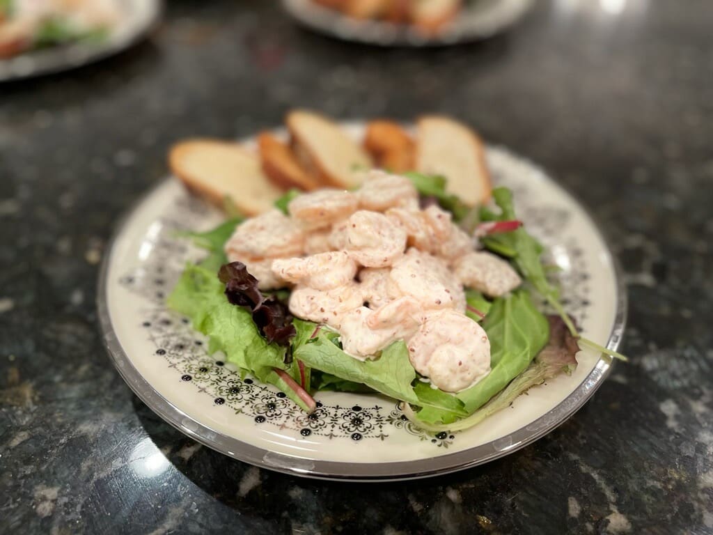 Seated dinner plate with shrimp over lettuce and bread